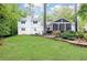 Backyard view of home with well-maintained lawn, screened porch, and landscaped garden, perfect for entertaining at 1329 W Nancy Creek Ne Dr, Brookhaven, GA 30319