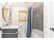 Charming bathroom with tub/shower, grey tiled walls, patterned wallpaper and lovely vanity at 1329 W Nancy Creek Ne Dr, Brookhaven, GA 30319
