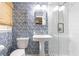 Charming bathroom showcasing a tiled shower with glass door, pedestal sink, and unique patterned wallpaper at 1329 W Nancy Creek Ne Dr, Brookhaven, GA 30319