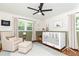 Inviting bedroom space with modern decor, a cozy armchair, and a baby crib set at 1329 W Nancy Creek Ne Dr, Brookhaven, GA 30319
