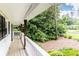 Inviting covered front porch featuring wood decking and natural wood posts surrounded by lush landscaping at 1329 W Nancy Creek Ne Dr, Brookhaven, GA 30319