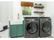 Modern laundry room equipped with a farmhouse sink, stylish cabinetry, and high-end washer and dryer at 1329 W Nancy Creek Ne Dr, Brookhaven, GA 30319