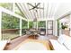 Relaxing screened porch with vaulted ceilings, ceiling fan, wood floors, and comfortable seating area at 1329 W Nancy Creek Ne Dr, Brookhaven, GA 30319
