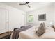 Bedroom with dark wood floor features neutral bedding, picture window, and modern ceiling fan at 2041 Trailwood Rd, Decatur, GA 30032