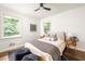 Bedroom with dark wood floor features neutral bedding, picture window, and modern ceiling fan at 2041 Trailwood Rd, Decatur, GA 30032