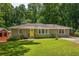 Charming home featuring a well-manicured lawn, mature landscaping, and a bright yellow front door at 2041 Trailwood Rd, Decatur, GA 30032