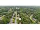 Aerial view of a wooded neighborhood with lush green trees and well-maintained lawns at 5519 Princeton Oaks Ln, Sugar Hill, GA 30518