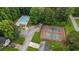 Aerial view of the community pool and tennis courts surrounded by mature trees and lush landscaping at 5519 Princeton Oaks Ln, Sugar Hill, GA 30518