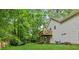 A well-maintained backyard showcasing a spacious deck, lush lawn and mature trees in a serene setting at 5519 Princeton Oaks Ln, Sugar Hill, GA 30518