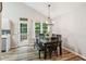 The dining area boasts hardwood floors, an elegant chandelier, and natural light from the door to the deck at 5519 Princeton Oaks Ln, Sugar Hill, GA 30518