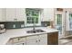View of a Kitchen sink with blue backsplash and window with outside view at 5519 Princeton Oaks Ln, Sugar Hill, GA 30518