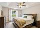 Comfortable main bedroom boasts a tray ceiling, plush carpet, and bright window at 5519 Princeton Oaks Ln, Sugar Hill, GA 30518