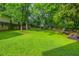 Large backyard with lush lawn, mature trees, and privacy fence at 176 Olympic Pl, Decatur, GA 30030