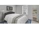 This staged bedroom features a comfortable bed, a bright window, and a stylish bookshelf at 2135 N Forest Trl, Dunwoody, GA 30338