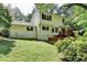 A view of the home's backyard featuring a wooden deck, lawn and mature landscaping at 10035 Anaheim Dr, Alpharetta, GA 30022