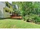 Exterior view of the home featuring a wooden deck and lush backyard at 10035 Anaheim Dr, Alpharetta, GA 30022