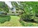 Back exterior view with an expansive lawn, mature trees, and back deck at 10035 Anaheim Dr, Alpharetta, GA 30022