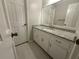 Bathroom vanity featuring granite countertop, white cabinetry, modern fixtures, and ample storage at 10035 Anaheim Dr, Alpharetta, GA 30022
