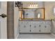 Bathroom vanity with double sinks, granite countertop, decorative mirror, and modern fixtures at 10035 Anaheim Dr, Alpharetta, GA 30022