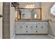 Bathroom vanity with double sinks, granite countertop, decorative mirror, and modern fixtures at 10035 Anaheim Dr, Alpharetta, GA 30022
