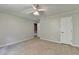 Spacious bedroom with neutral walls, plush carpet, ceiling fan, and two closets at 10035 Anaheim Dr, Alpharetta, GA 30022