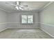Bright bedroom featuring neutral walls, carpet, and a ceiling fan, illuminated by natural light from the window at 10035 Anaheim Dr, Alpharetta, GA 30022