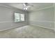 Bright bedroom featuring neutral walls, carpet, and a ceiling fan, illuminated by natural light from the window at 10035 Anaheim Dr, Alpharetta, GA 30022