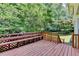 Spacious wooden deck with built in bench seating overlooking a lush backyard at 10035 Anaheim Dr, Alpharetta, GA 30022