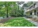 Expansive front yard with lush lawn, mature trees, and a charming walkway to the house at 10035 Anaheim Dr, Alpharetta, GA 30022