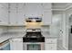 Close-up of a kitchen showing white cabinets, granite countertops, and stainless steel appliances at 10035 Anaheim Dr, Alpharetta, GA 30022