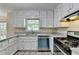 Well-appointed kitchen with white cabinets, granite countertops, and stainless steel appliances offers a modern touch at 10035 Anaheim Dr, Alpharetta, GA 30022