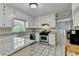 Well-lit kitchen with white cabinetry, granite countertops and stainless steel appliances offers ample counter space at 10035 Anaheim Dr, Alpharetta, GA 30022