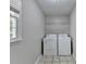 Functional laundry room with a window and shelving above the washer and dryer at 10035 Anaheim Dr, Alpharetta, GA 30022