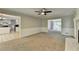 Spacious living room featuring neutral walls, plush carpeting, and a view to the home's kitchen at 10035 Anaheim Dr, Alpharetta, GA 30022
