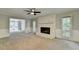 Spacious living room featuring neutral walls, plush carpeting, and a view to the home's sitting room and fireplace at 10035 Anaheim Dr, Alpharetta, GA 30022
