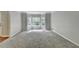 Bright living room with large windows providing natural light, plush carpet, and neutral decor at 10035 Anaheim Dr, Alpharetta, GA 30022