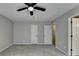 Primary bedroom featuring gray carpet, neutral walls, and three doors at 10035 Anaheim Dr, Alpharetta, GA 30022