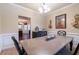 Inviting dining area featuring a neutral color scheme, classic lighting fixture, and views into the living area at 12275 Styron Dr, Hampton, GA 30228