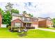Inviting two-story brick home with green lawn and chairs on a beautiful day at 12275 Styron Dr, Hampton, GA 30228