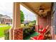 Inviting front porch featuring brick columns, ceiling fans, outdoor seating, and a view of the neighborhood at 12275 Styron Dr, Hampton, GA 30228