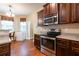 Kitchen featuring stainless steel appliances, dark wood cabinets, and hardwood floors at 12275 Styron Dr, Hampton, GA 30228