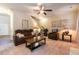 Cozy living room features plush furniture, a ceiling fan, and access to the staircase at 12275 Styron Dr, Hampton, GA 30228