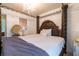 A luxurious main bedroom featuring a four-poster bed, elegant chandelier, and neutral color palette at 12275 Styron Dr, Hampton, GA 30228