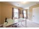 A home office with a modern desk, chair, and windows with decorative curtains at 12275 Styron Dr, Hampton, GA 30228