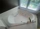 Relaxing bathroom featuring a corner jacuzzi tub with tile surround at 2295 Amberbrook Lane Ln, Grayson, GA 30017