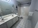 Bathroom with dual sinks, large mirror, tile floors, and shower-tub combo at 2295 Amberbrook Lane Ln, Grayson, GA 30017