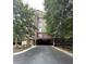 Modern brick apartment building featuring covered parking and mature trees at 3150 Woodwalk Se Dr # 3112, Atlanta, GA 30339