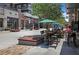 Outdoor dining area at The Battery Atlanta, featuring tables, chairs, umbrellas, and access to local shops at 3150 Woodwalk Se Dr # 3112, Atlanta, GA 30339