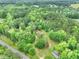 Expansive aerial view of a wooded property, showcasing its secluded location and surrounding natural beauty at 4060 Highway 81, Hampton, GA 30228
