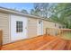 Back of home with wooden deck overlooking a lush green backyard surrounded by mature trees at 4060 Highway 81, Hampton, GA 30228